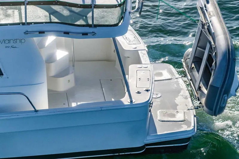 Slide: The Image of 1997 Mainship 350 Trawler with dinghy, docked on calm water. - 5