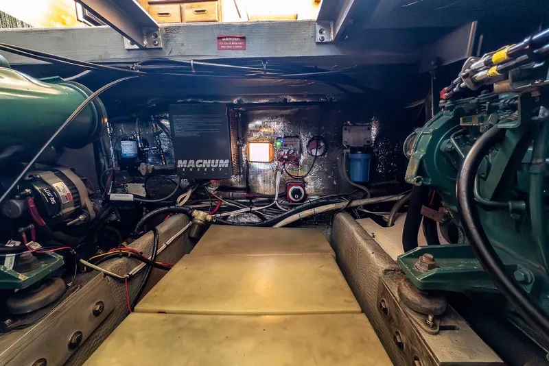 Slide: The Image of Engine room of a 1997 Mainship 350 Trawler, showcasing machinery and wiring. - 52