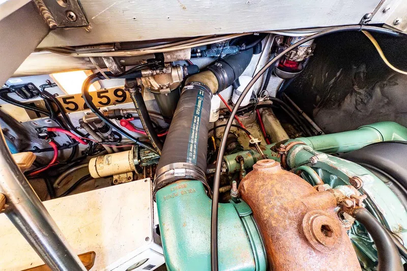 Slide: The Image of Engine room of a 1997 Mainship 350 Trawler, showcasing mechanical components and wiring. - 54