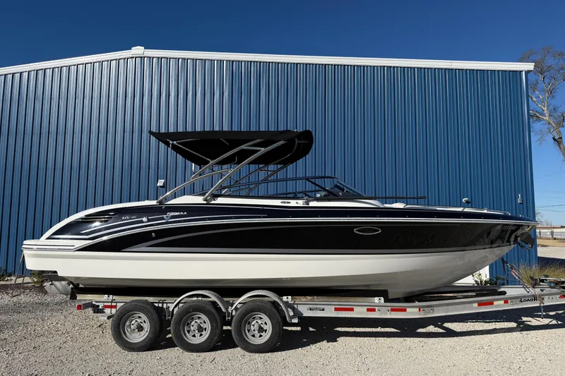 Slide: The Image of 2019 Formula 270 Bowrider boat on trailer, parked by blue building. - 2
