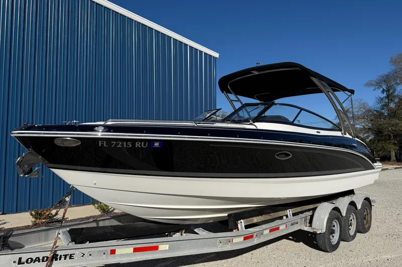 Slide: The Image of 2019 Formula 270 Bowrider boat on trailer, parked near blue building. - 3