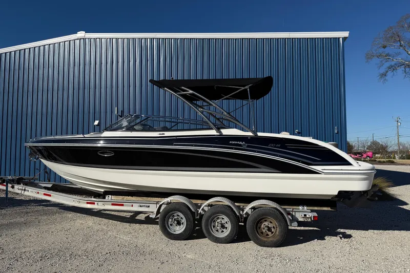 Slide: The Image of 2019 Formula 270 Bowrider boat on trailer, parked by blue building. - 5