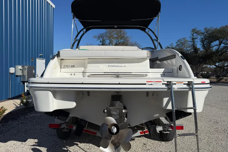 Slide: The Image of 2019 Formula 270 Bowrider boat, rear view with ladder and propeller, parked outdoors. - 7
