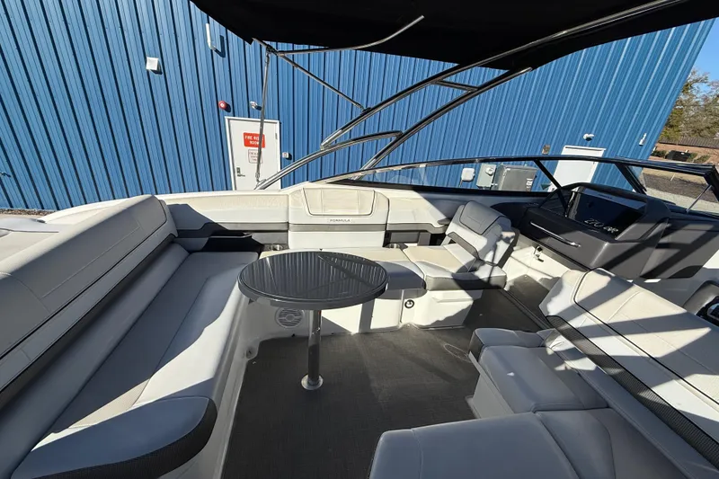 Slide: The Image of 2019 Formula 270 Bowrider interior with seating and table, docked near blue building. - 9