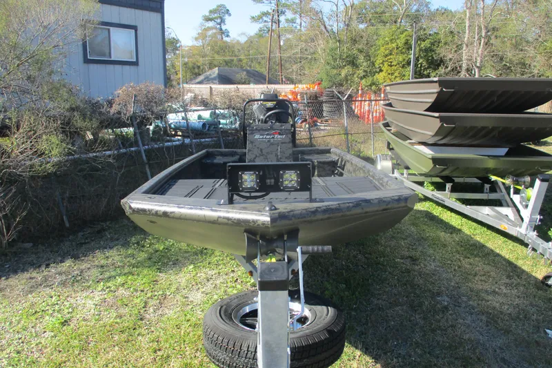 Slide: The Image of 2026 Gator Tail 1860 Extreme boat on trailer, outdoors, with trees and buildings in background. - 2