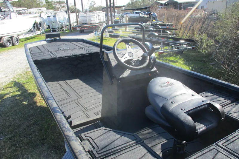 Slide: The Image of 2026 Gator Tail 1860 Extreme boat with steering console and seating, parked outdoors. - 3