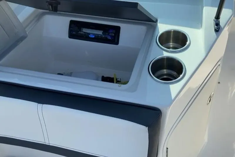 Slide: The Image of 2016 Sea Ray SPX 210 Outboard boat interior with storage compartment and cup holders. - 13