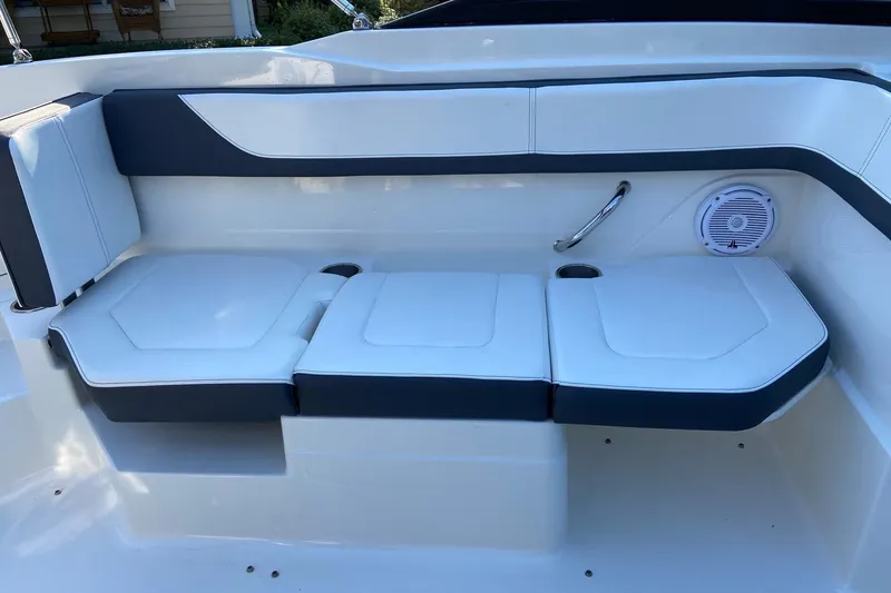 Slide: The Image of 2016 Sea Ray SPX 210 Outboard boat seating with white and gray cushions, speaker, and cup holder. - 14