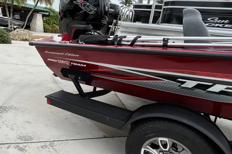 Slide: The Image of 2024 Tracker Pro Team 190 boat, red exterior, parked on a trailer. - 10