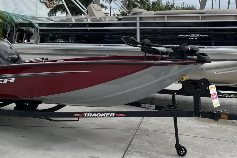 Slide: The Image of 2024 Tracker Pro Team 190 boat on trailer, red and gray design, outdoor display. - 12