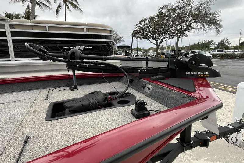 Slide: The Image of 2024 Tracker Pro Team 190 boat with Minn Kota Maxxum trolling motor, parked near palm trees. - 8