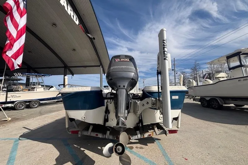 Slide: The Image of 2001 Bay Stealth 2230 boat with V6 200 engine at a marina under a clear sky. - 2