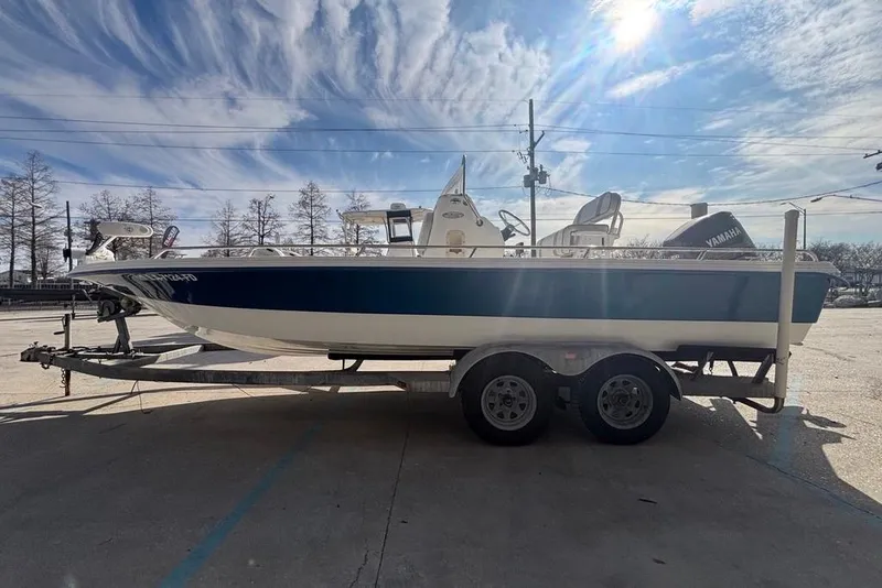 Slide: The Image of 2001 Bay Stealth 2230 boat on trailer under a bright, cloudy sky. - 4