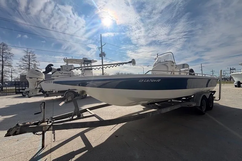 Slide: The Image of 2001 Bay Stealth 2230 boat on trailer under a bright, sunny sky. - 5