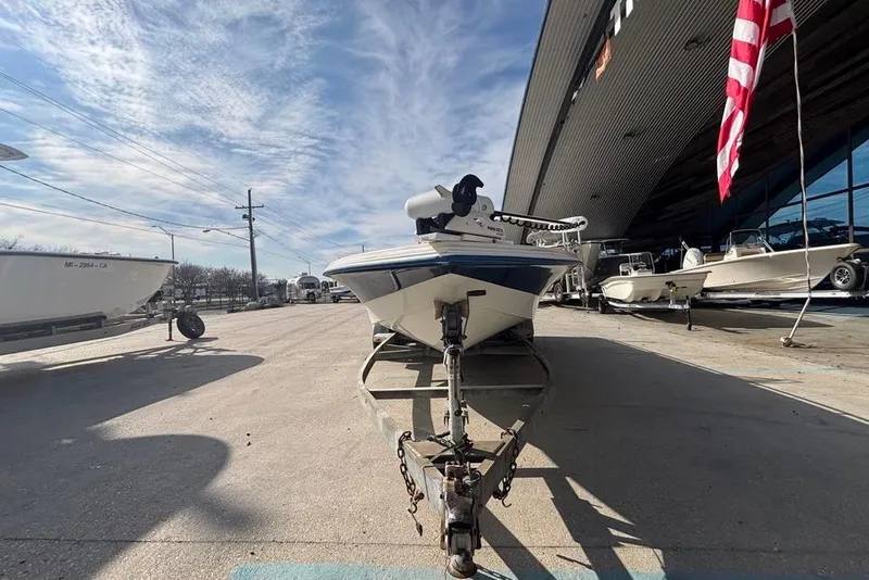 Slide: The Image of 2001 Bay Stealth 2230 boat on trailer, parked outdoors under a clear sky. - 6