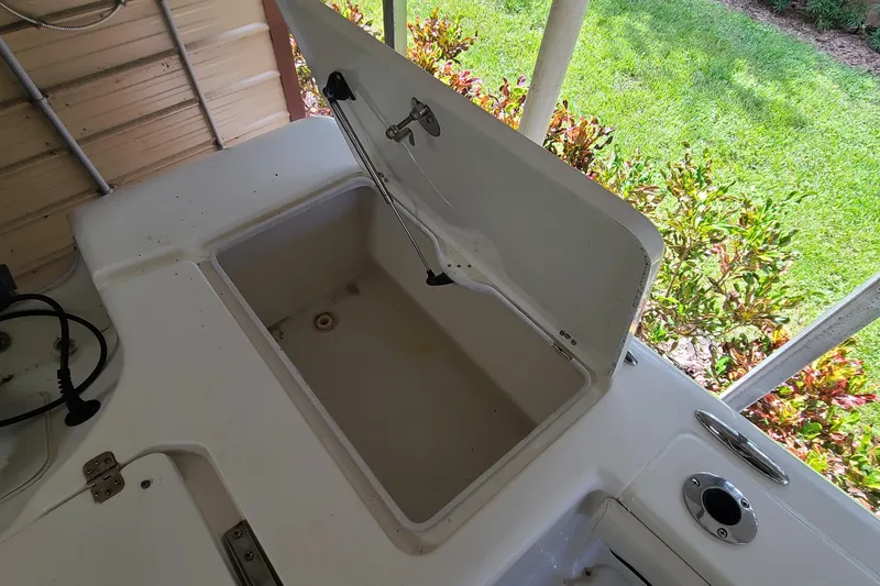 Slide: The Image of Open storage compartment on 2008 Key West 246 Bay Reef boat, surrounded by greenery. - 11