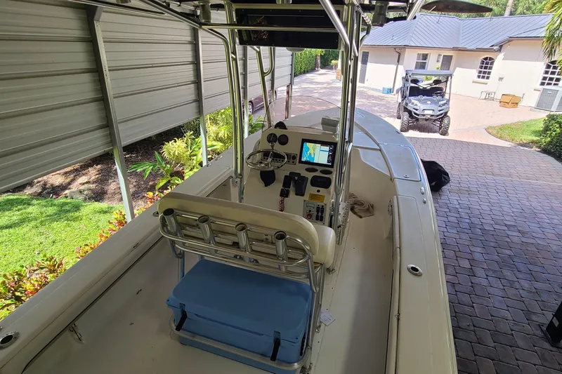 Slide: The Image of 2008 Key West 246 Bay Reef boat with center console and navigation equipment, parked under a shelter. - 20