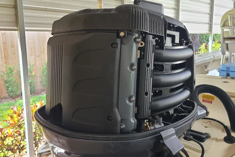 Slide: The Image of 2008 Key West 246 Bay Reef boat engine under maintenance in a covered area. - 27