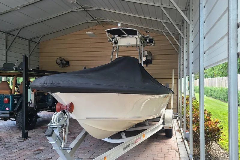 Slide: The Image of 2008 Key West 246 Bay Reef boat covered and stored in a metal shelter. - 29