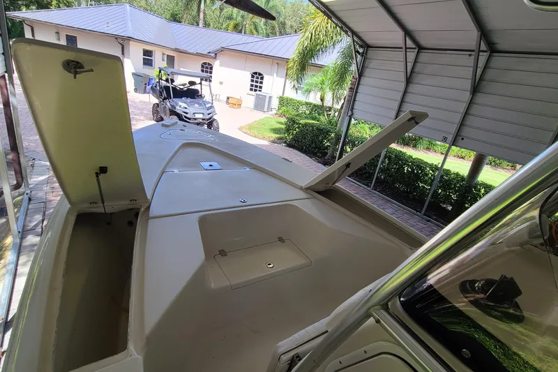 Slide: The Image of 2008 Key West 246 Bay Reef boat under a carport, showcasing open storage compartments. - 4