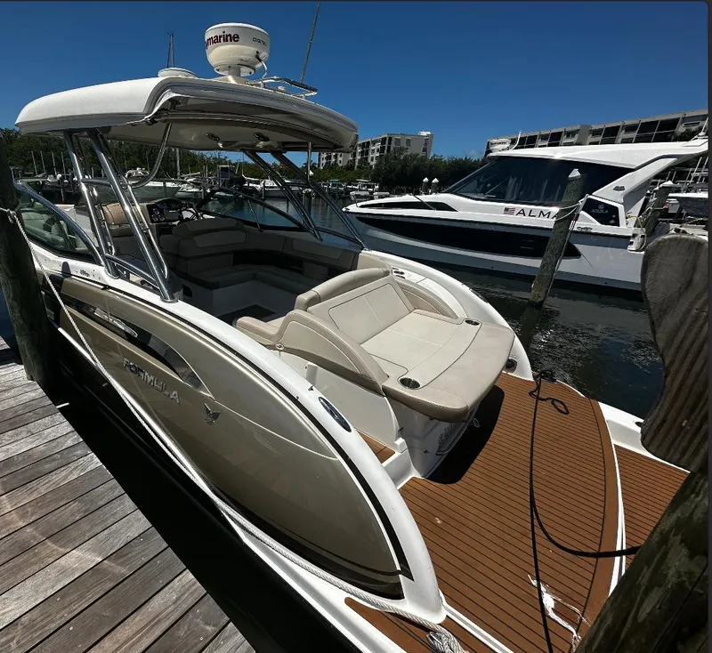 Slide: The Image of 2014 Formula 350 Crossover Bowrider docked at marina, showcasing sleek design and spacious seating. - 17