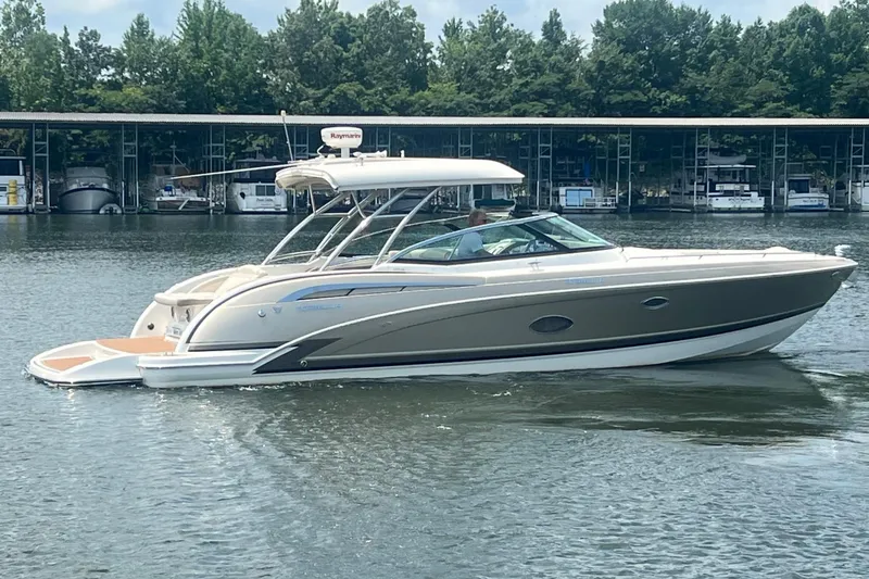 Slide: The Image of 2014 Formula 350 Crossover Bowrider on a calm lake near a marina. - 2