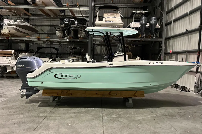 Slide: The Image of 2023 Robalo R242 Center Console boat in storage, featuring Yamaha outboard engine. - 0