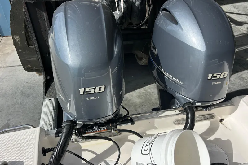 Slide: The Image of 2023 Robalo R242 Center Console boat interior with helm, rod holders, and cooler. - 11