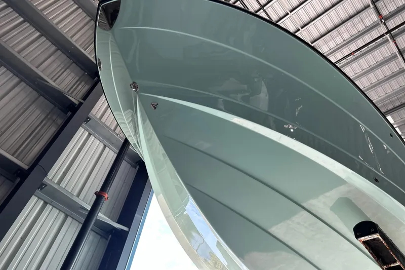 Slide: The Image of 2023 Robalo R242 Center Console boat with dual Yamaha 150 engines in a marina storage. - 2