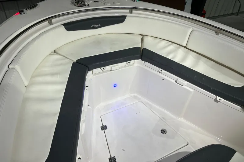 Slide: The Image of 2023 Robalo R242 Center Console boat interior with cushioned seating and storage area. - 20