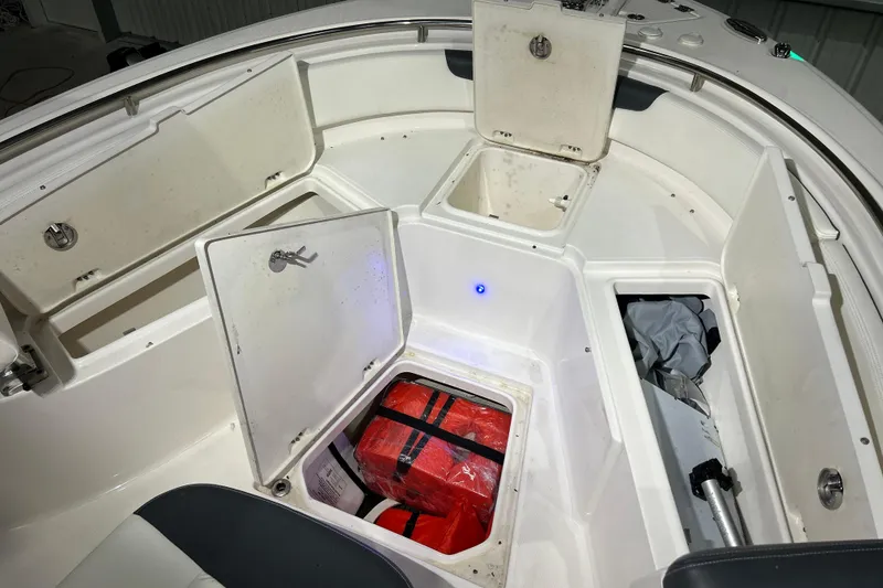 Slide: The Image of 2023 Robalo R242 Center Console boat storage compartments with safety equipment. - 21
