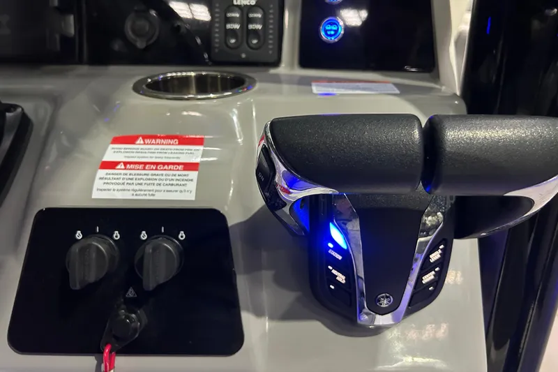 Slide: The Image of 2023 Robalo R242 Center Console boat controls with throttle and warning labels. - 25