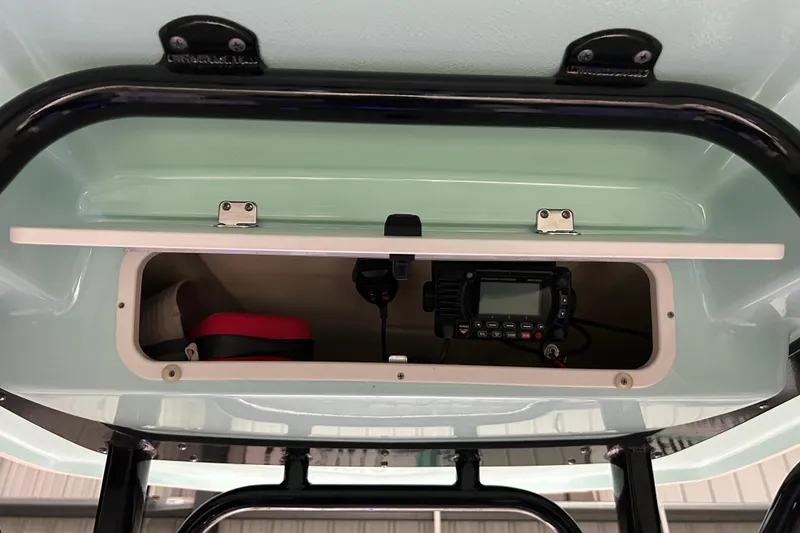 Slide: The Image of 2023 Robalo R242 Center Console storage compartment with radio equipment. - 27