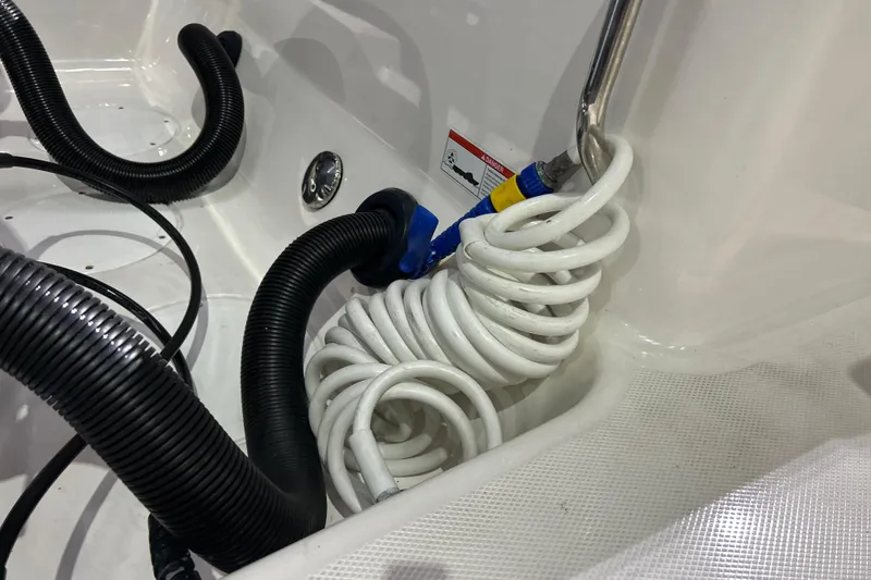 Slide: The Image of Coiled hose and tubing in 2023 Robalo R242 Center Console boat interior. - 28