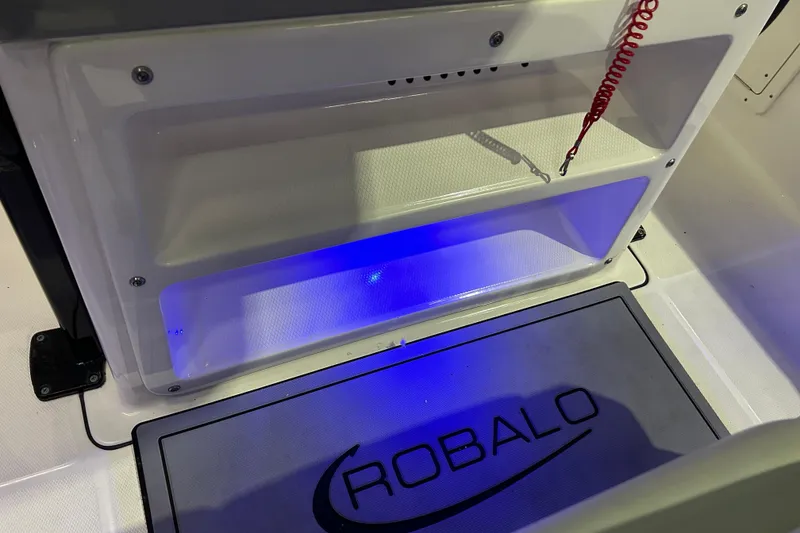 Slide: The Image of 2023 Robalo R242 Center Console interior with blue LED lighting and branded mat. - 33
