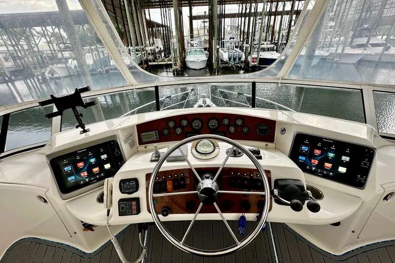 Slide: The Image of 2005 Silverton 43 Motor Yacht helm with modern navigation displays and steering wheel. - 15