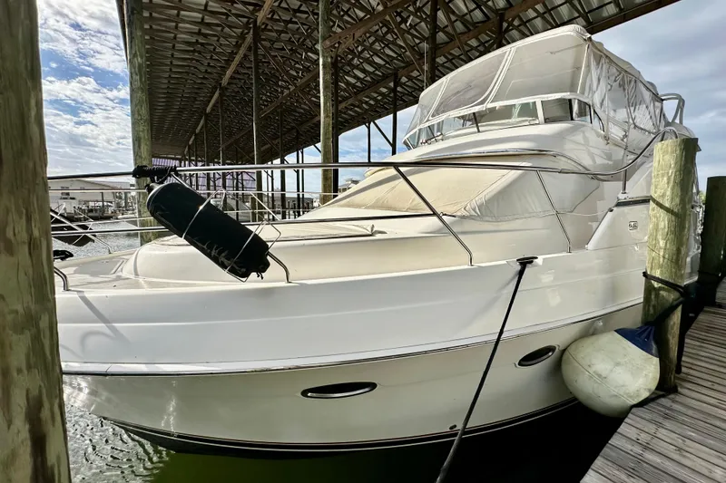 Slide: The Image of 2005 Silverton 43 Motor Yacht docked under a covered marina. - 2