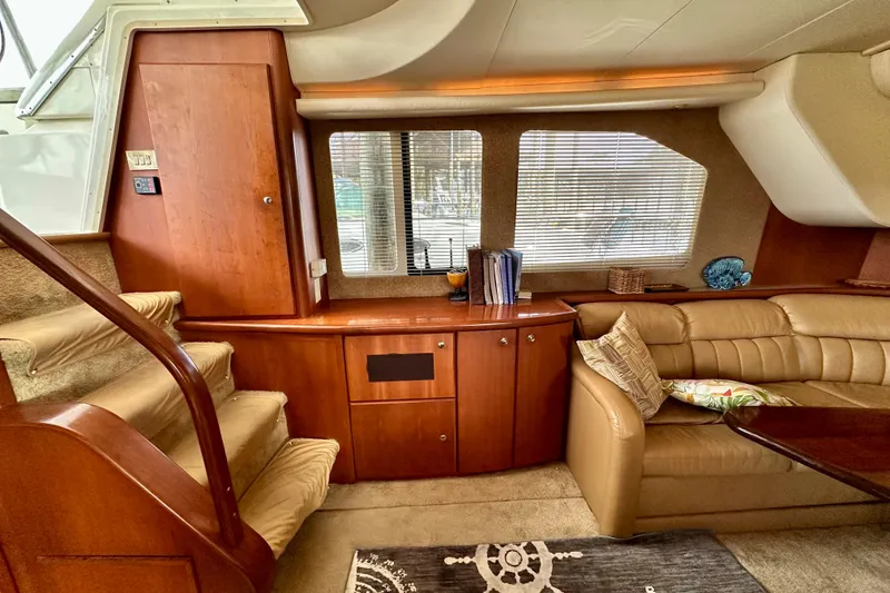 Slide: The Image of Interior of 2005 Silverton 43 Motor Yacht with plush seating and wooden cabinetry. - 21