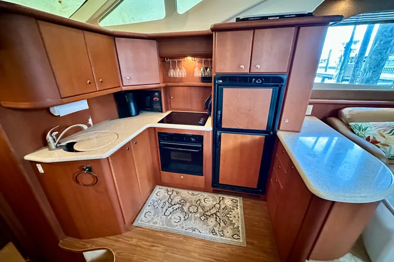 Slide: The Image of Luxurious 2005 Silverton 43 Motor Yacht kitchen with wood cabinetry and modern appliances. - 25