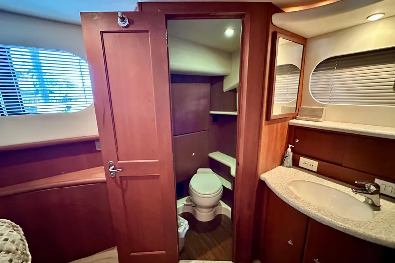 Slide: The Image of 2005 Silverton 43 Motor Yacht bathroom with wooden cabinetry and modern fixtures. - 28