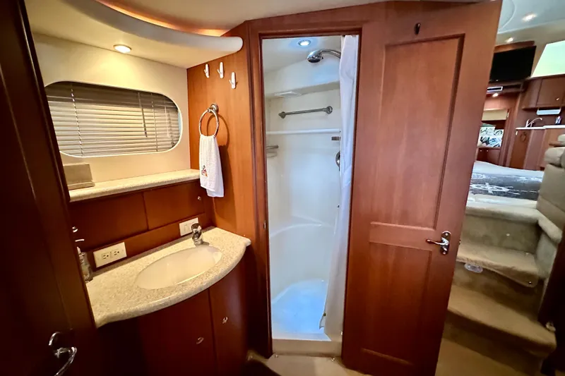 Slide: The Image of 2005 Silverton 43 Motor Yacht bathroom with shower, sink, and wooden cabinetry. - 29