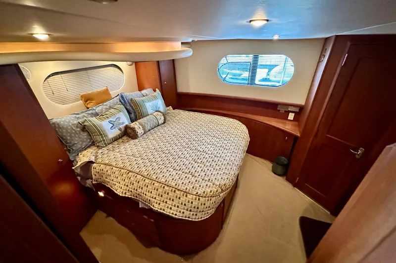 Slide: The Image of Luxurious bedroom in 2005 Silverton 43 Motor Yacht with cozy bedding and elegant wood finishes. - 31
