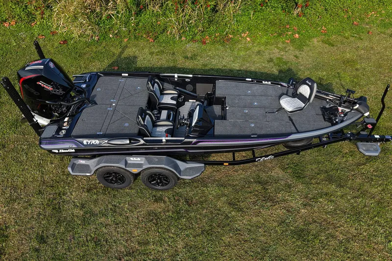 Slide: The Image of 2026 Bass Cat Eyra SP fishing boat on grass, showcasing sleek design and spacious interior. - 3