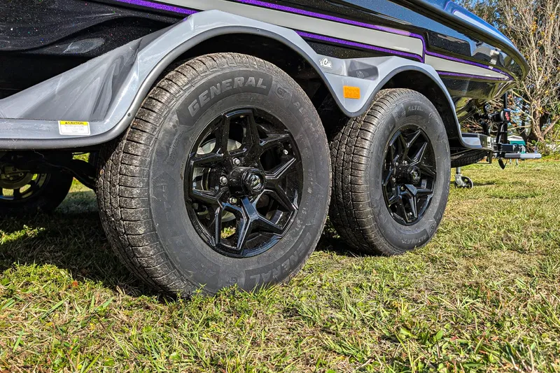 Slide: The Image of 2026 Bass Cat Eyra SP trailer with black wheels on grass. - 6