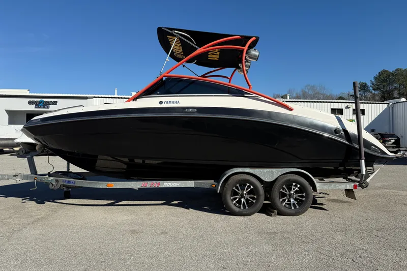 The Image of 2011 Yamaha Boats AR240 HO on trailer, black and white design, parked outdoors. - 0