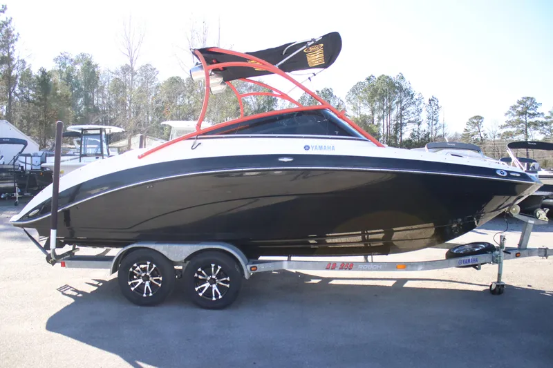 Slide: The Image of 2011 Yamaha Boats AR240 HO on trailer, black and white design, parked outdoors. - 2