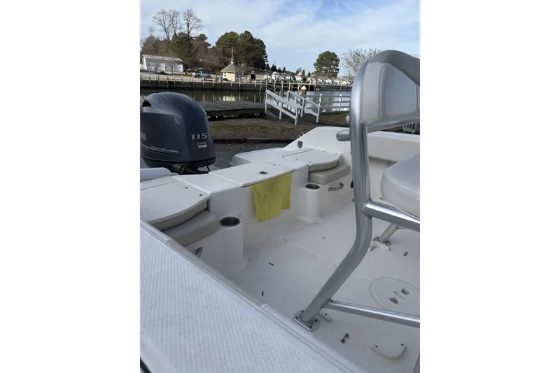 Slide: The Image of 2016 Robalo R180 Center Console boat interior with Yamaha 115 engine, docked by a marina. - 4