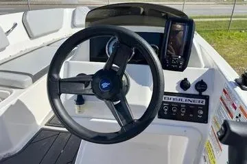Slide: The Image of 2024 Bayliner Element M15 boat dashboard with steering wheel and controls. - 2