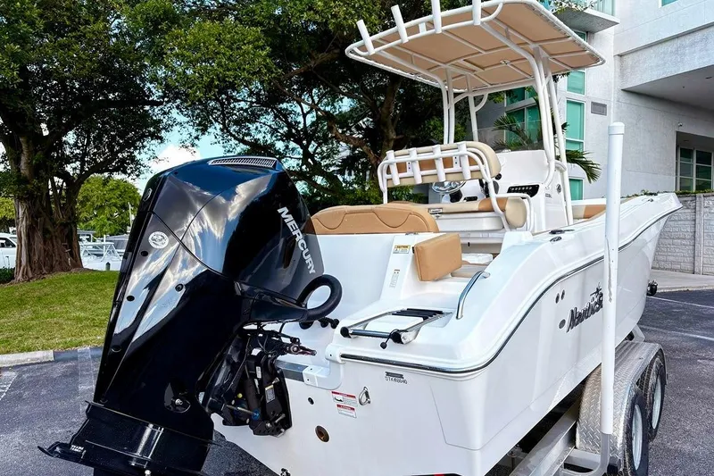 Slide: The Image of 2024 NauticStar 222 Offshore boat with Mercury engine, parked outdoors. - 5