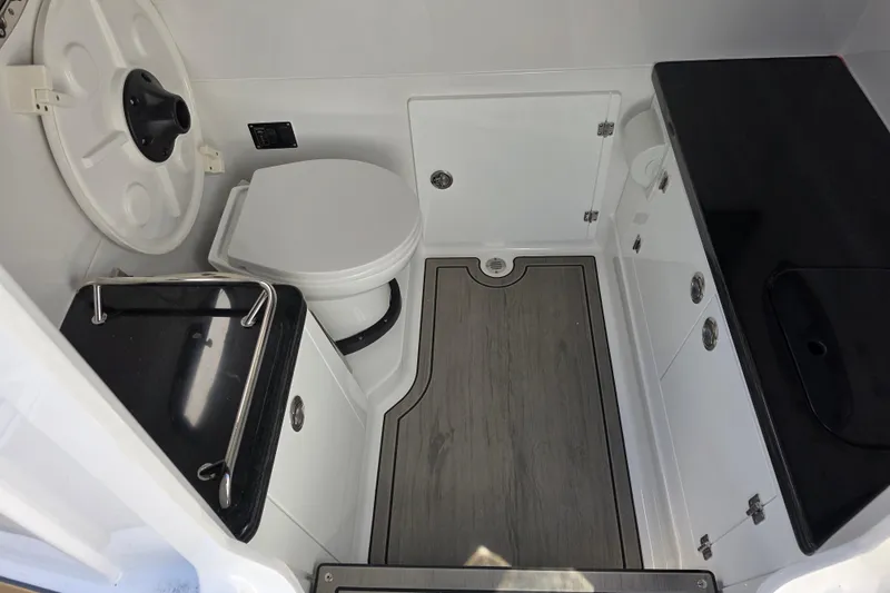 Slide: The Image of 2026 Monterey Elite 30 OB boat bathroom with modern fixtures and wood-style flooring. - 21